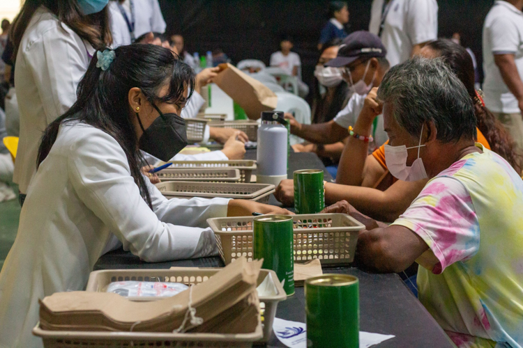 A pharmacist teaches a patient how to take the medicines and vitamins properly.