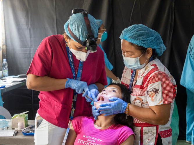 Dentists work together in helping the patient during the tooth extraction procedure.