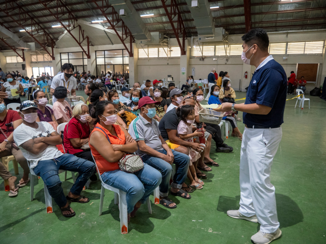 A Tzu Chi volunteer calls out the patients' names as he helps in collecting their prescriptions.