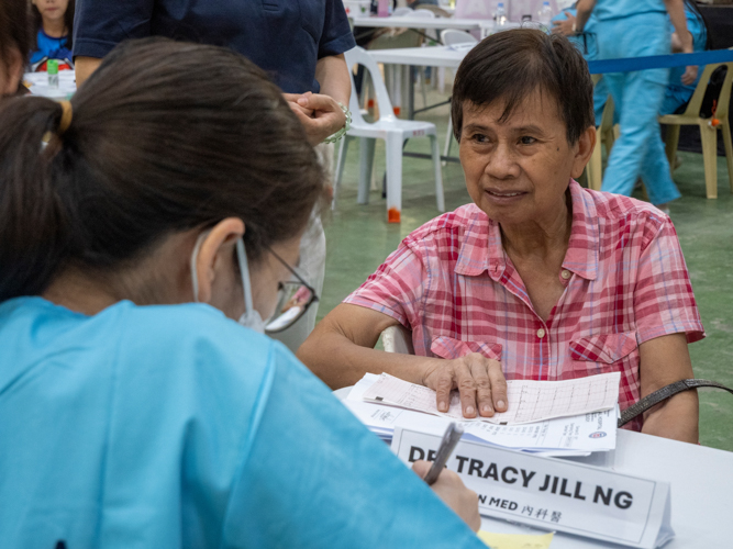 A patient pays attention as the doctor notes down instructions for her medication.