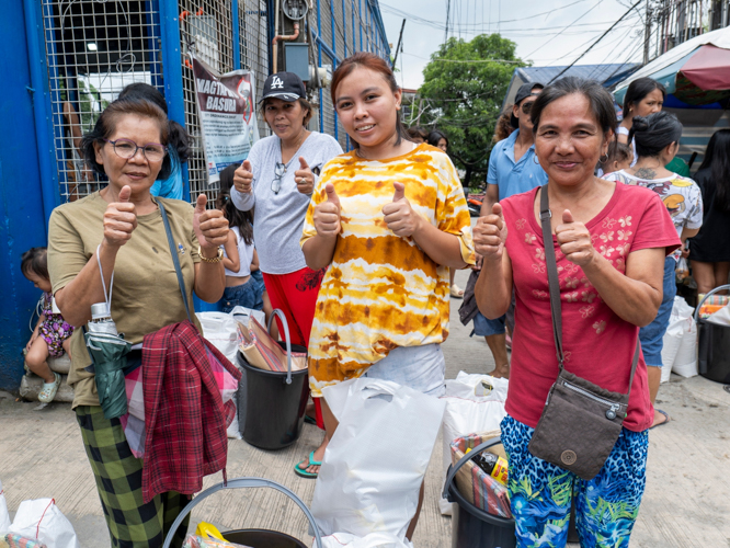 Beneficiaries are all smiles as they leave the distribution area with Tzu Chi’s relief goods. 