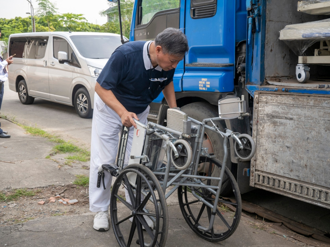 In Manila, a Tzu Chi volunteer checks the condition of a wheelchair before sending them to Bicol.