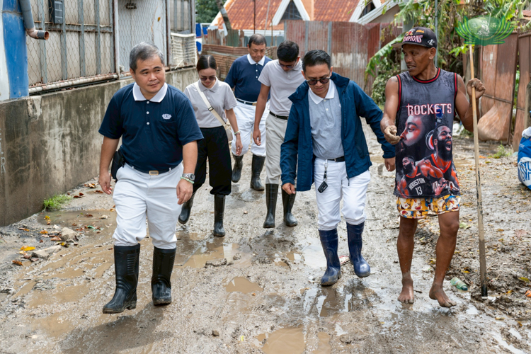 Tzu Chi volunteers walk through the muddied roads as they conduct their ocular surveys.