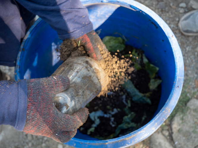 The process of composting includes layering the soil as well as the fruit and vegetable peels continuously, leaving only about five inches of space from the top of the container. 【Photo by Matt Serrano】