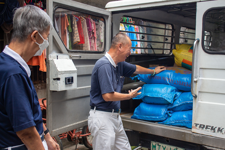 Tzu Chi volunteers Rudy Ong (left) and Luis Diamante (right) were delighted to see the generous amount of goods to be given to Blind Republic Philippines.  【Photo by Marella Saldonido】