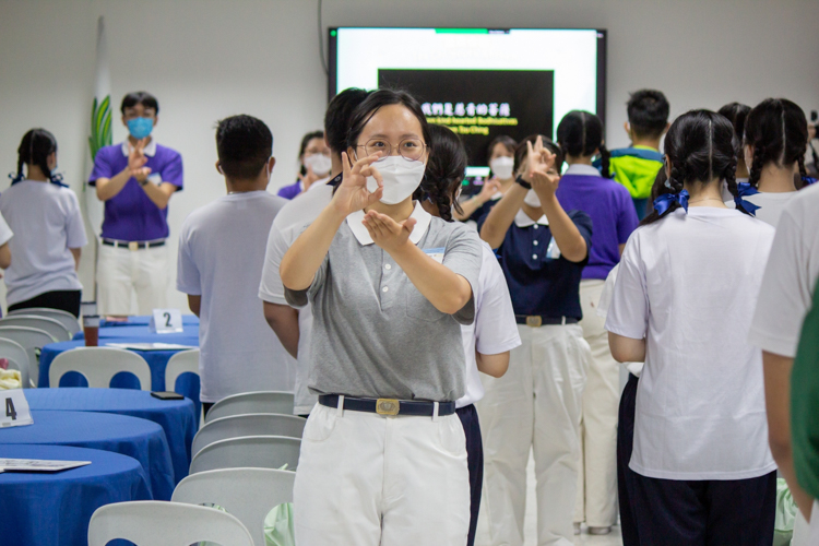 Camp head Miaolin Li helps demo the Tzu Chi Youth anthem sign language to the participants.【Photo by Marella Saldonido】