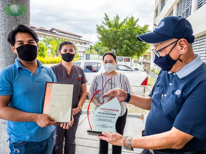 Tzu Chi Philippines CEO Henry Yuñez (far right) receives a plaque of appreciation from Taguig-Pateros District Hospital staff (from left) Generic Millano, Grace Anne V. Apostol, and Maria Imee G. San Gabriel. 【Photo by Kendrick Yacuan】