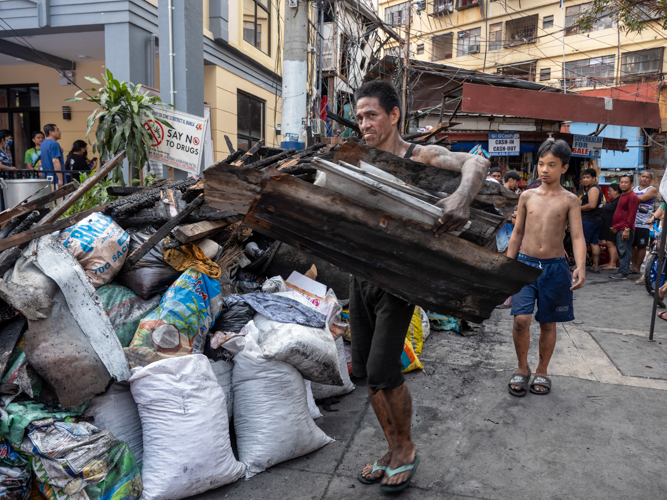 A man salvages materials that may be of use after the fire. 【Photo by Matt Serrano】