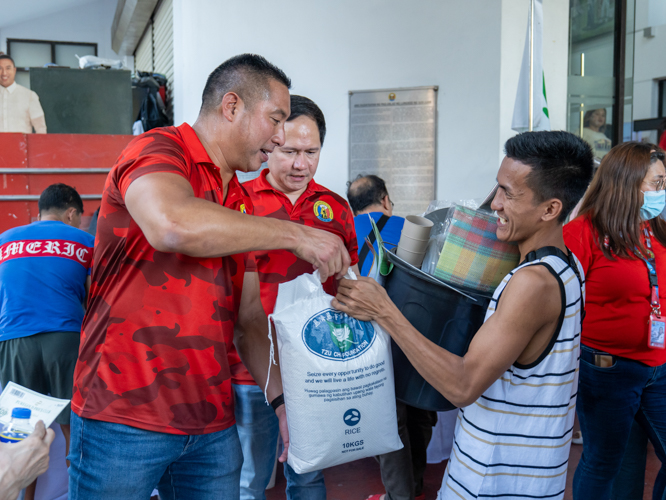 A constituent happily claims a 10-kg sack of Tzu Chi rice from Mayor Francis Zamora. 【Photo by Marella Saldonido】