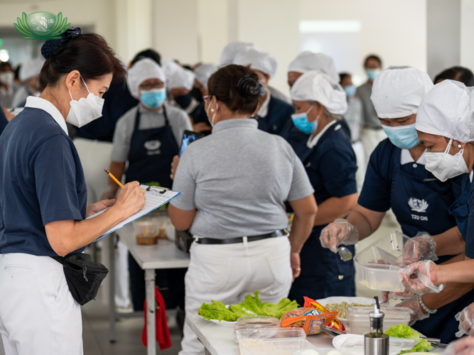One of the Tzu Chi volunteer judges appraising ingredient and cooking method【Photo by Daniel Lazar】