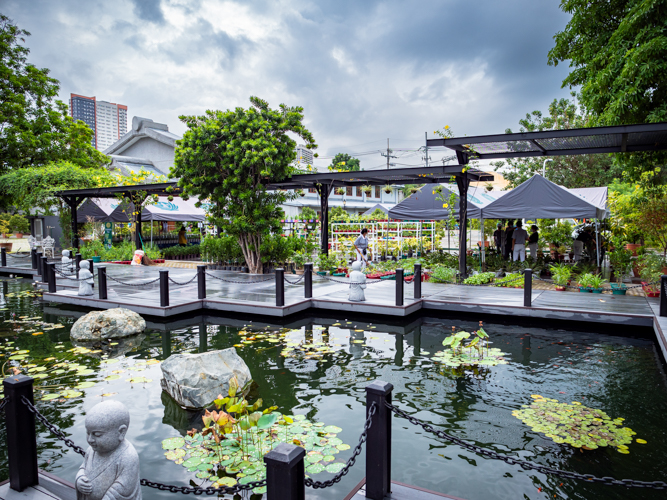 View of the pond looking towards Jing Si Hall, and the potted plants for sale at the bazaar.【Photo by Daniel Lazar】