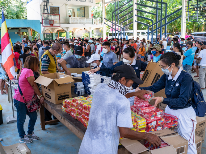 Local volunteers helping Tzu Chi volunteers distribute food items for recipients.【Photo by Daniel Lazar】
