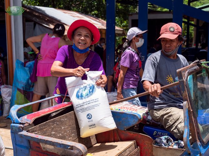 Recipient Susana Pataray with a big smile loading her relief goods into a tricycle.【Photo by Daniel Lazar】