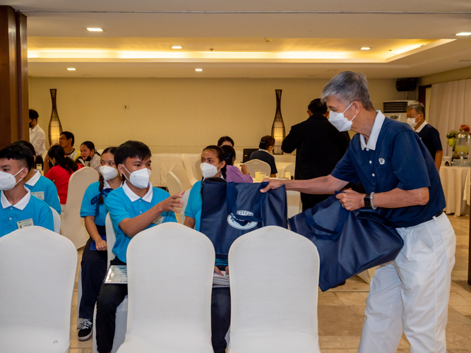 Tzu Chi volunteer handing out bags with supplies for the students.【Photo by Daniel Lazar】
