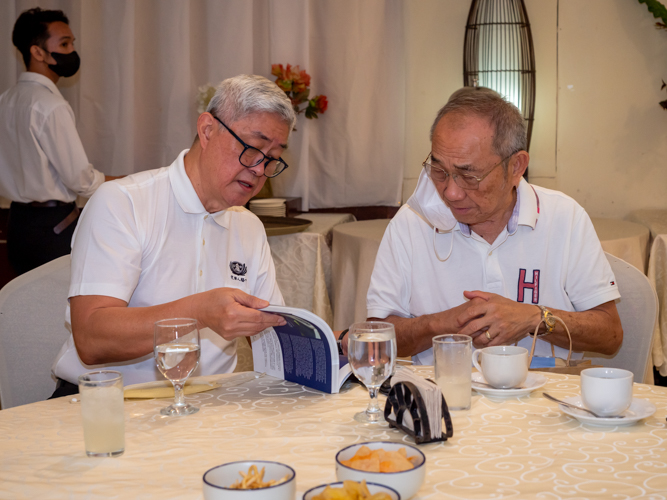 Dr. Joe Qua showing the Tzu Chi book "A Mission of Love" to Mr. Alfonso Tan.【Photo by Daniel Lazar】