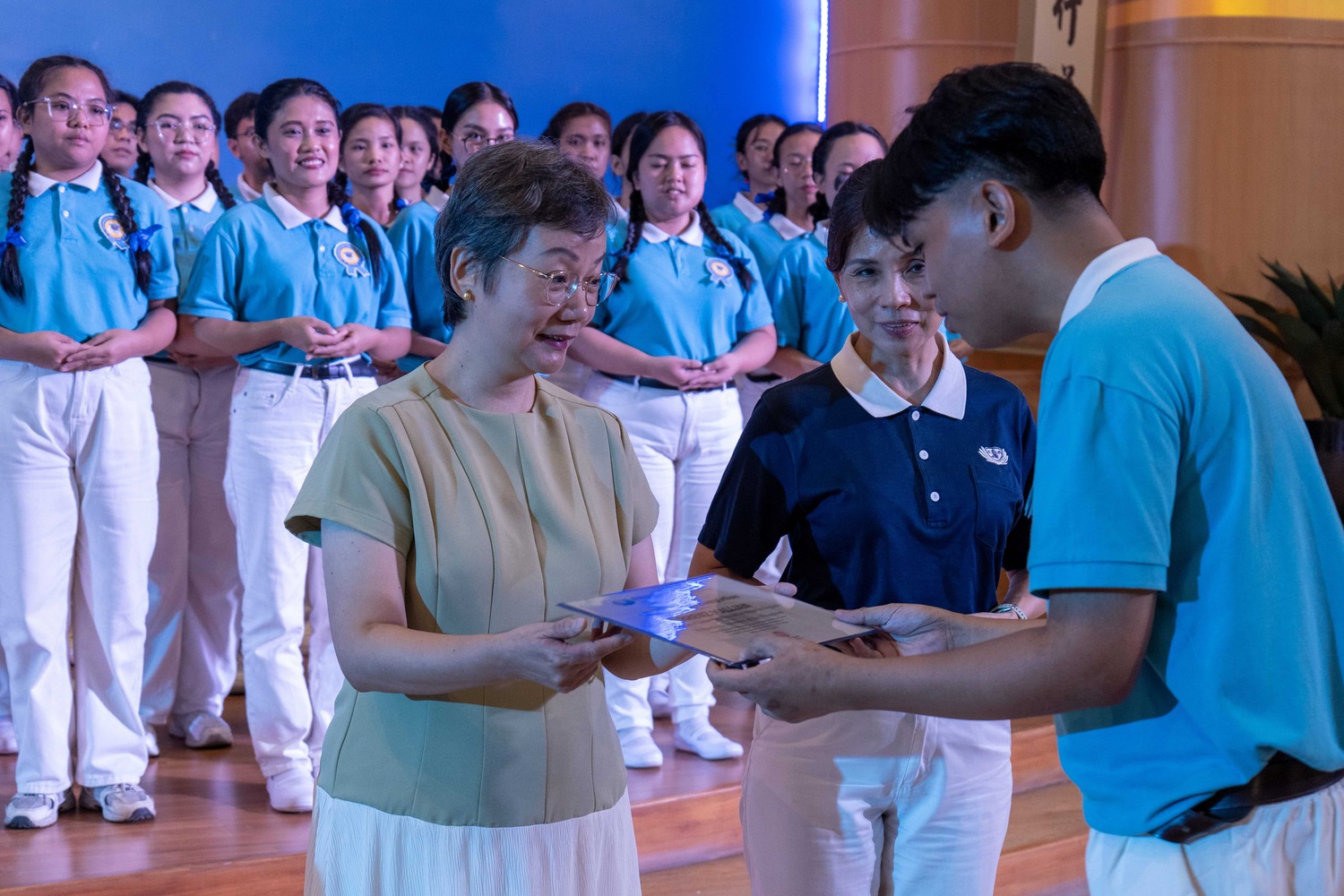 Abigail See of the John and Mary Kaw Charitable Foundation, Inc. (left) joins Tzu Chi Davao Deputy OIC Mei Yuen in presenting graduating scholars with their certificate. 