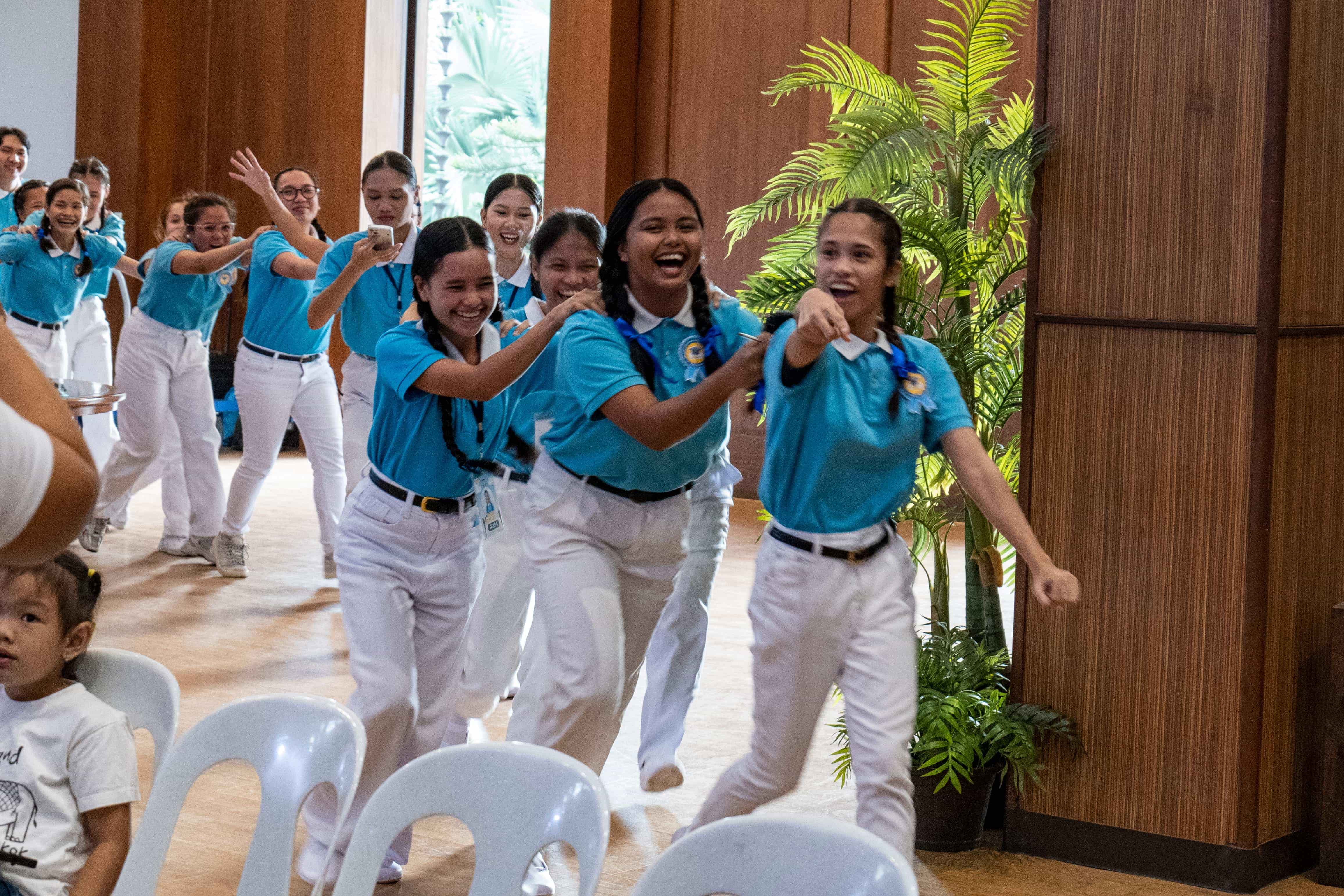 In what has become a tradition in scholars’ camps, Camp Head Heart Baquilar leads fellow scholars in the spirited line dance for “Pulling the Ox Cart,” a song about achieving great things through dedication and teamwork. 