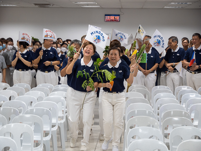 Waving flags, volunteers from Metro Manila, Bicol, Bohol Cebu, Davao, Palo, Pampanga, and Zamboanga make a lively entrance before the start of the planning session of the Tzu Chi 2023 Annual Meeting. 【Photo by Marella Saldonido】