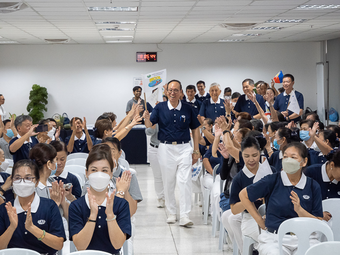 Waving flags, volunteers from Metro Manila, Bicol, Bohol Cebu, Davao, Palo, Pampanga, and Zamboanga make a lively entrance before the start of the planning session of the Tzu Chi 2023 Annual Meeting. 【Photo by Marella Saldonido】