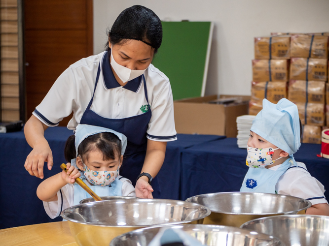 Teacher Pauline Paje guides student in mixing ingredients in a bowl. 【Photo by Daniel Lazar】
