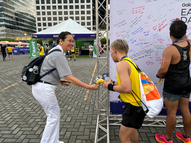 A volunteer at Runrio’s Galaxy Watch Earth Day Run on April 21 at the SM Mall of Asia concert grounds, Joy Gatdula hands a Tzu Chi flyer to a runner post-race.