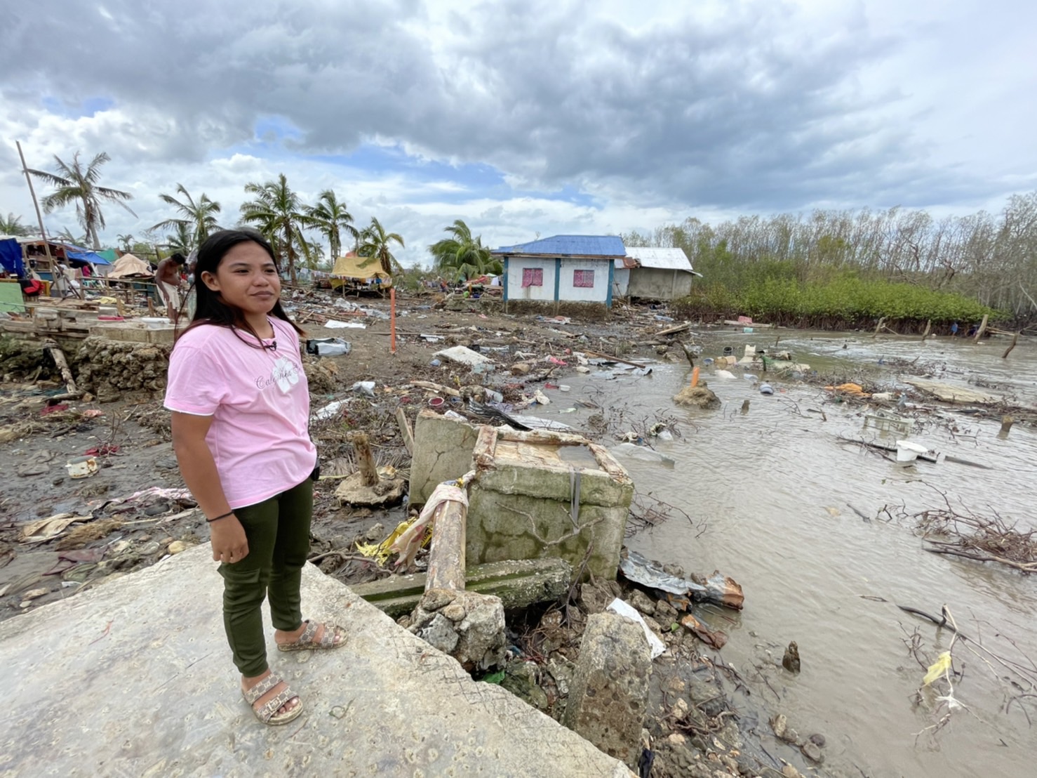 Feljoy Torreon stands on the cement flooring of her home, the only thing remaining of her family’s residence in Tinangnan, Tubigon, Bohol. 【Photo by Jeaneal Dando】