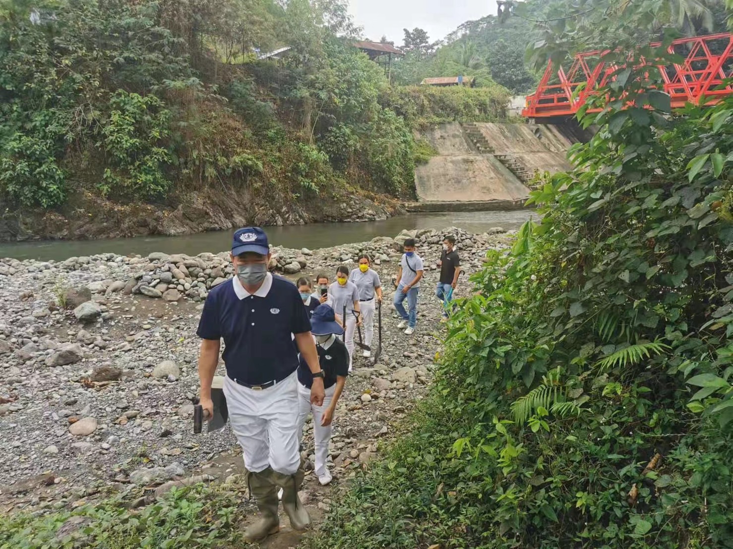 With shovel in hand, Tzu Chi Davao volunteers led by Nelson Chua trek through rocky terrain to get to the site where they will help plant banana seedlings. 