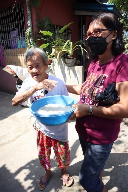 Cecilia Alcedera (right) divided her rice relief with five neighbors whose names weren’t included in the list prepared by the local government. Among those she shared her rice with was 78-year-old Erlinda Casimondo (left). “It tastes really good! This is such a blessing!” she said.