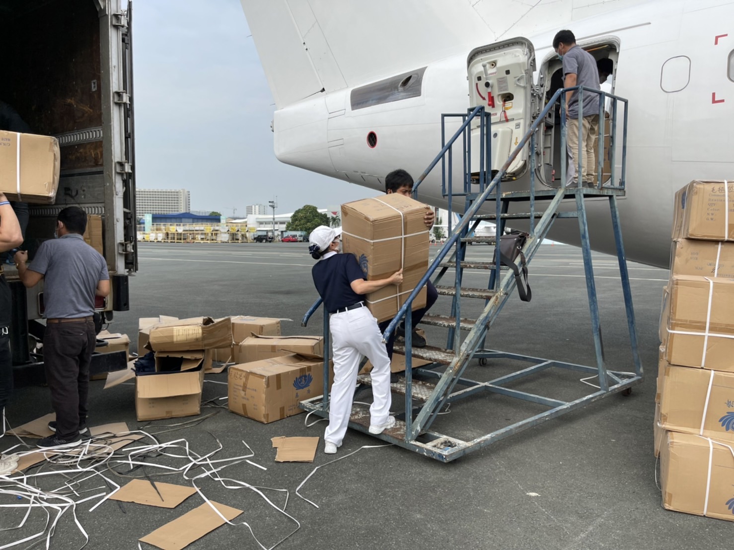 Tzu Chi volunteers load boxes of blankets into the private plane. 
