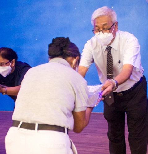 Eliza Abragon bows as she receives her volunteer uniform from Tzu Chi Philippines CEO Henry Yuňez. 【Photo by Matt Serrano】