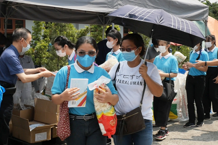 Mom Gina Tamina (right) accompanies her daughter Nigielza in claiming groceries as part of the benefits of being a Tzu Chi scholar. 【Photo by Marella Saldonido】