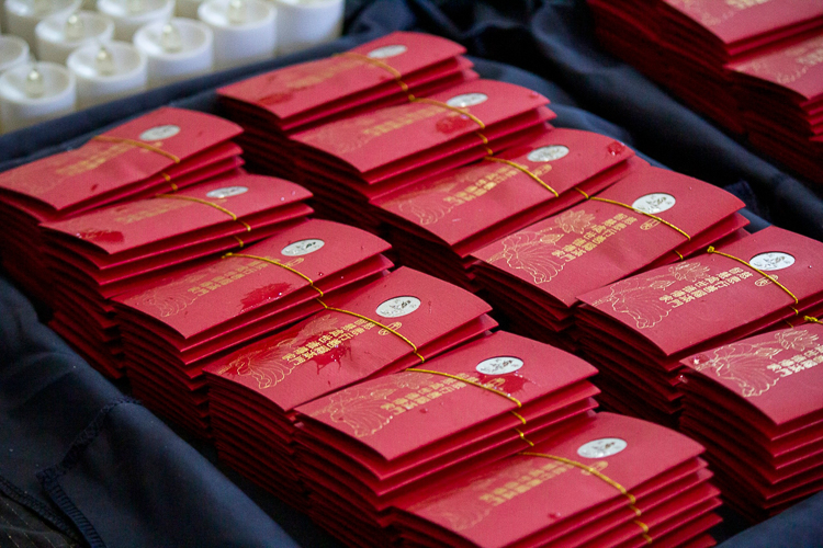 The parishioners receive a red envelope (angpao) blessed by Tzu Chi founder Dharma Master Cheng Yen. 【Photo by Marella Saldonido】