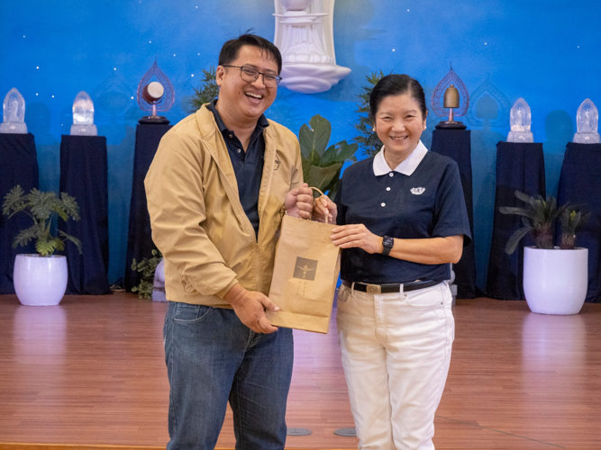 Elvin Mercader (left) receives a token of appreciation from Tzu Chi Education Committee Head Rosa So. 