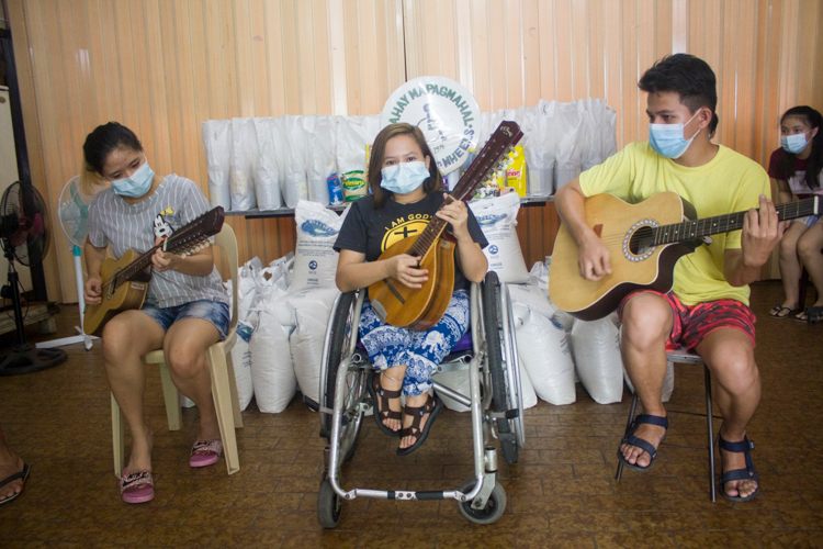Donna Rose Tidalgo (center) and members of Rondalla on Wheels perform for Tzu Chi volunteers. 【Photo by Matt Serrano】