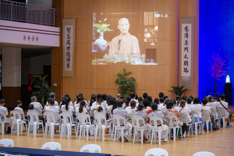 Beneficiaries and their families listen as Master Cheng Yen discusses the lesson behind the story “The Misfortune of a Woman.” 【Photo by Matt Serrano】