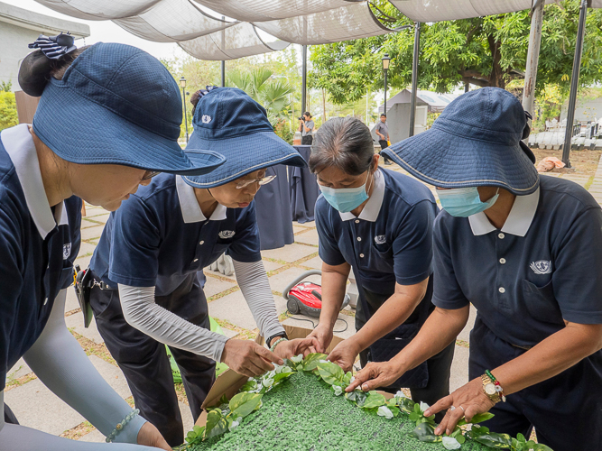 Working together harmoniously contributes to the success of large-scale celebrations like May 12’s 3-in-1 event. Volunteers help put green and white accents on a table for the Buddha Bathing Ceremony.