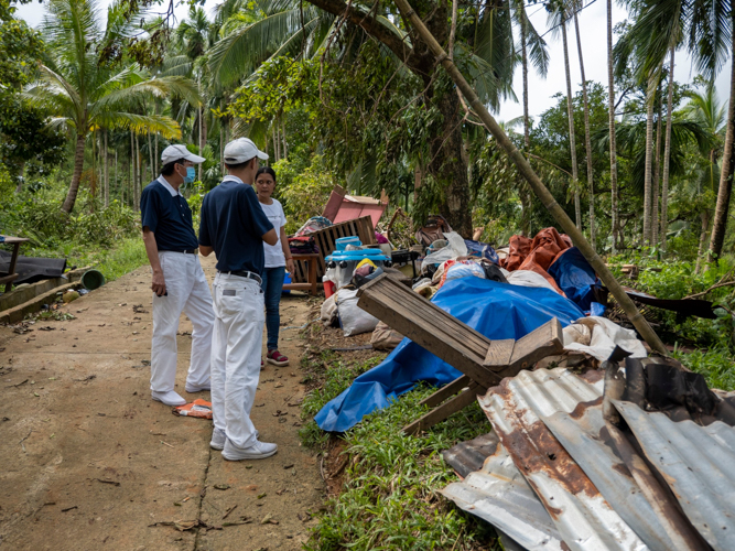 Tzu Chi volunteers interview a woman whose belongings have been swept to the side by the storm. 【Photo by Harold Alzaga】