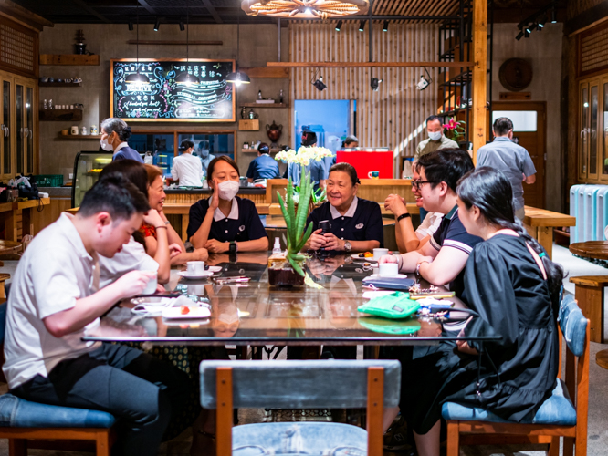 Volunteers and guests share a light moment at the BTCC coffee shop. 【Photo by Daniel Lazar】
