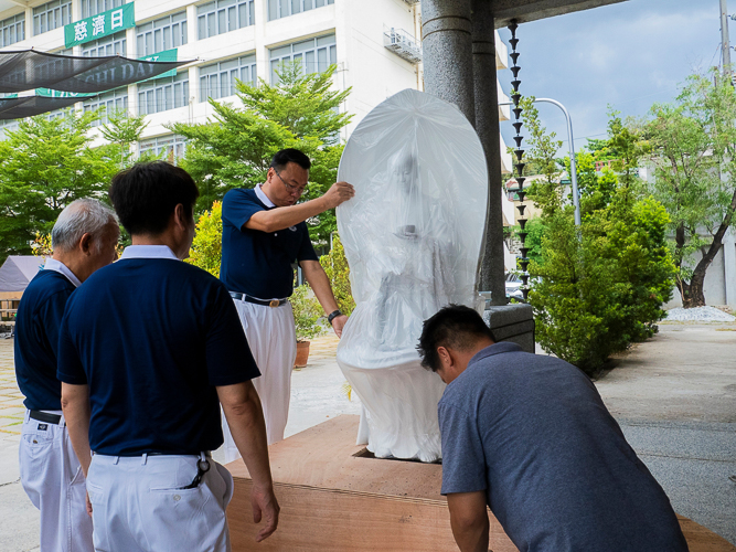 To assemble the centerpiece, Tzu Chi Philippines Deputy CEO Wilson Hung carefully handles the large image of Buddha. Brought in from Taiwan, it will be the first thing staffers and guests see when they enter Unity Hall. 
