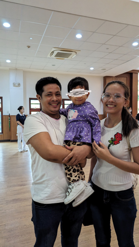 Baby Bella happily smiles for a photo with her parents during Tzu Chi’s Charity Day.