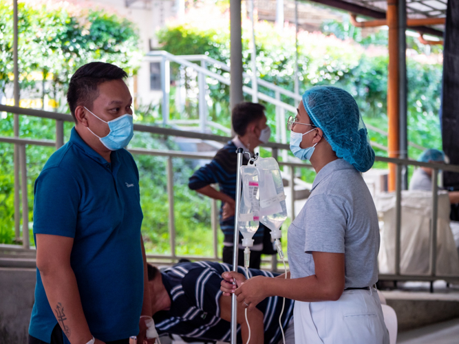 Tzu Chi Zamboanga volunteer Lisiel Bacayo addresses a patient’s concern at the holding area. 【Photo by Daniel Lazar】