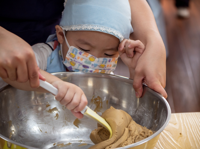 Preschool student participates in Tikoy making supervised by his teacher. 【Photo by Daniel Lazar】