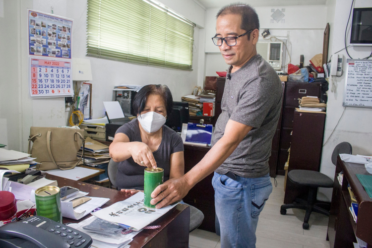 Virgilio collects donation from his co-worker. 【Photo by Matt Serrano】