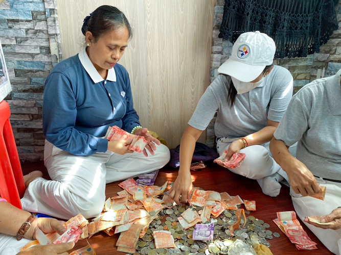 Tzu Chi volunteers count their collections from their morning round of street fundraising. 【Photo by Matt Serrano】