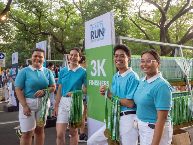 Tzu Chi scholars help award medals to finishers.