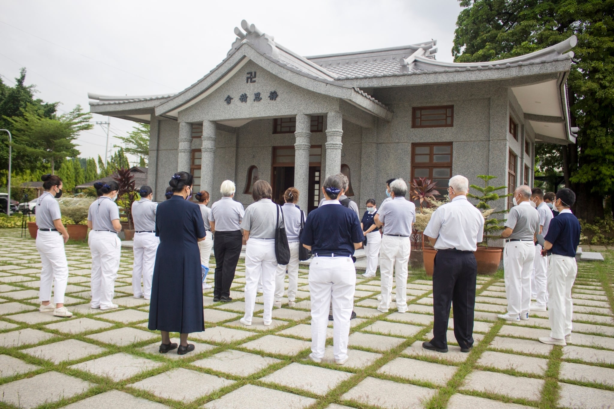 Volunteers in training face a replica of the Jing Si Abode, considered the spiritual home of all Tzu Chi members.