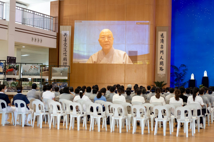 After the 3 steps and a bow followed by a light breakfast, volunteers attend a talk by Dharma Masters livestreamed from Hualien, Taiwan. 【Photo by Matt Serrano】