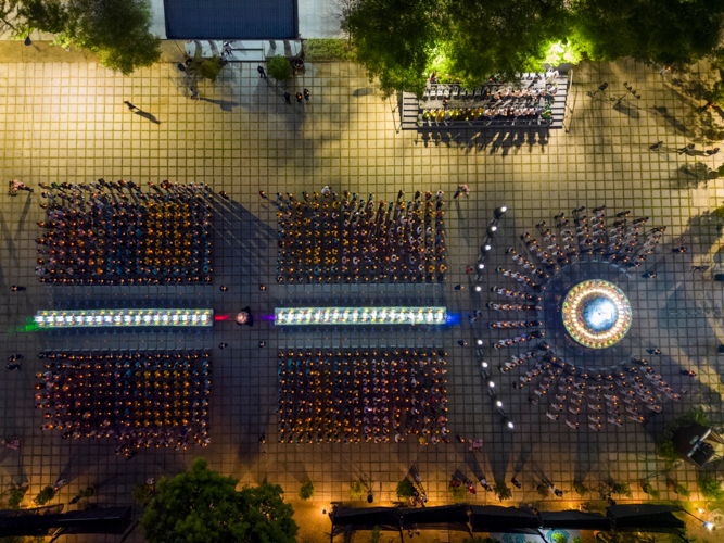 Drone shot of the closing ceremony where attendees raise their lotus candles and sing a prayer for peace.