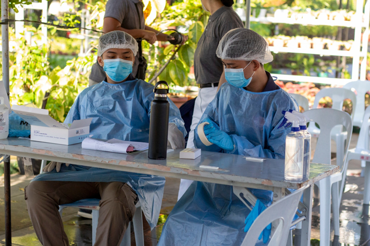Volunteers assist in the rapid antigen swabbing of Tzu Chi staff. 【Photo by Matt Serrano】
