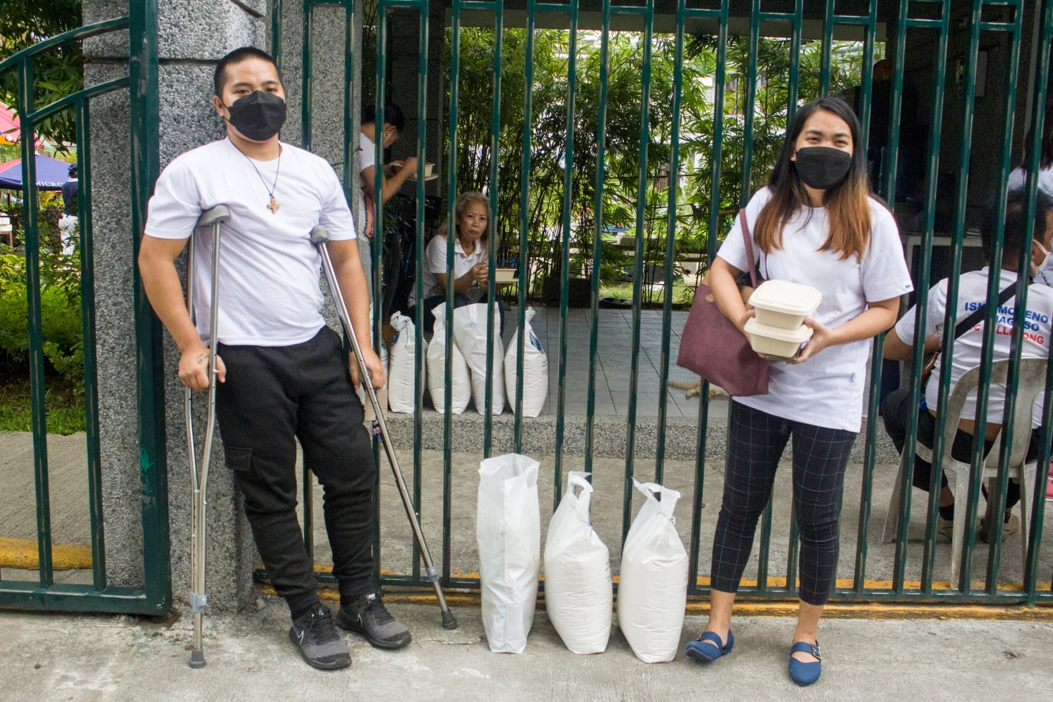 Christian Dave Delmonte (left) and Myrelle Espinosa wait for their ride home outside the BTCC compound.【Photo by Matt Serrano】